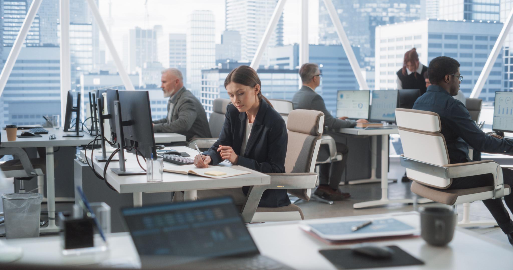Woman working in a high-rise office with several colleagues